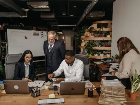 Two accountants reviewing documents and a laptop at a desk